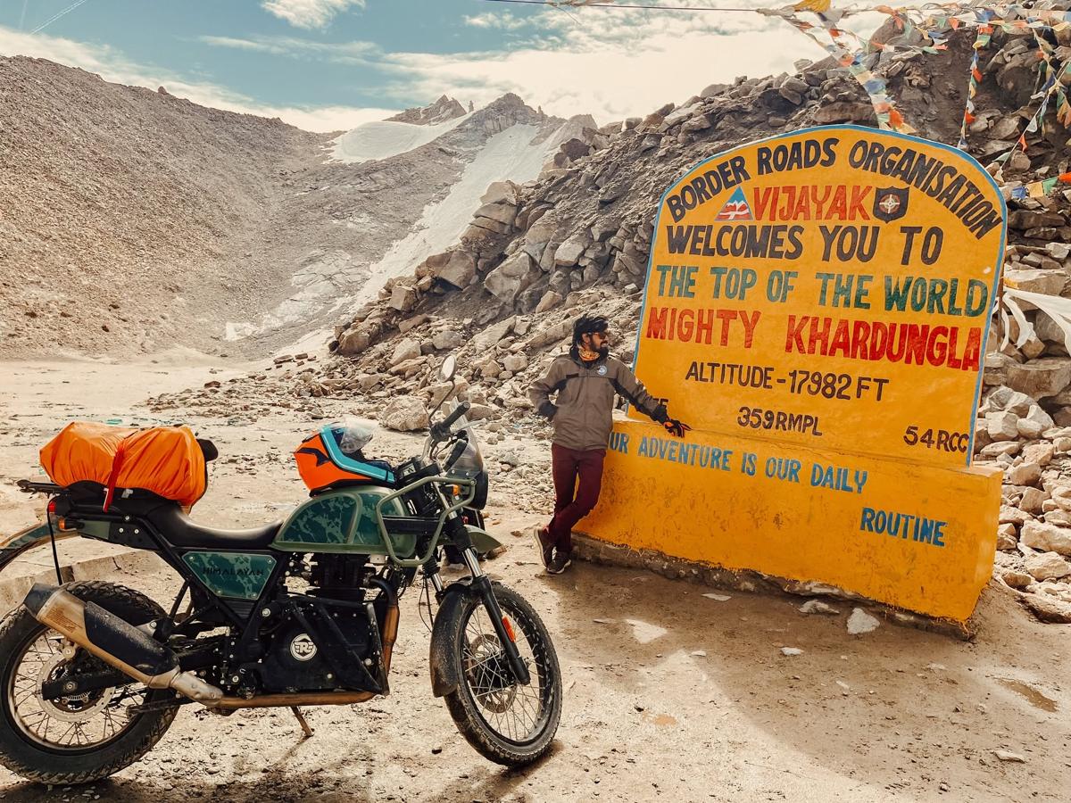 Akibul Islam with his motorcycle at Khardung La, Ladakh